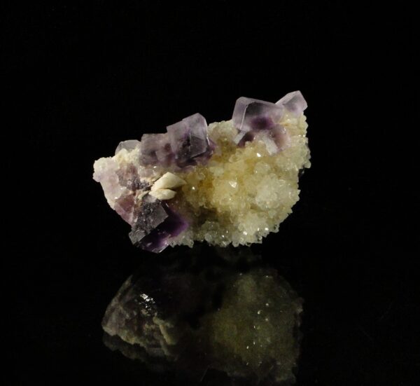 Ce sont des cubes de fluorite sur des cristaux de quartz, une pièce pour collectionneur de minéraux.