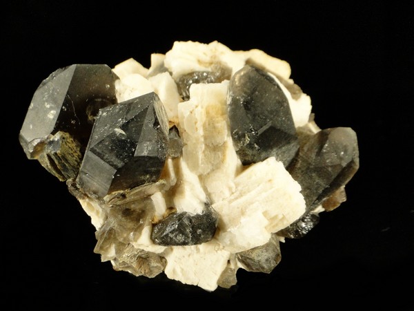 Des cristaux de quartz fumé avec de l'orthose, ce sont des minéraux pour collectionneur.